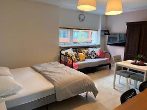 a bedroom with a bed and a couch and a table at Assad and Naveera, Steekkant 40 in Barendrecht