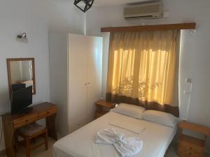 a small bedroom with a bed and a window at Eleni Palace in Amoudara Herakliou