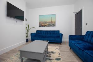 a living room with two blue couches and a tv at Stylish Stay Near The Stadium Walk To The Action in Liverpool