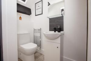 a white bathroom with a toilet and a sink at Stylish Stay Near The Stadium Walk To The Action in Liverpool