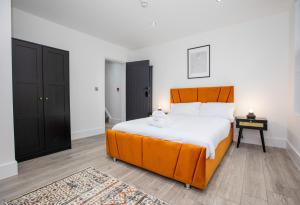 a bedroom with a king sized bed with an orange headboard at Stylish Stay Near The Stadium Walk To The Action in Liverpool