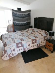 a bedroom with a bed with a quilt on it at Au coeur des landes in Carneville