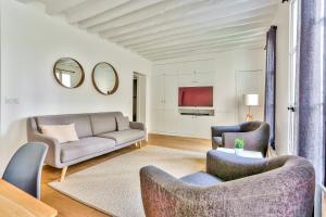 uma sala de estar com um sofá e duas cadeiras em Superbe Appartement Bon marché Saint Germain em Paris