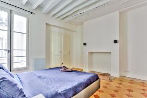 a bedroom with a bed and a large window at Superbe Appartement Bon marché Saint Germain in Paris