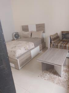 um pequeno quarto com uma cama e um banco em منزل الضيافة em Rabat
