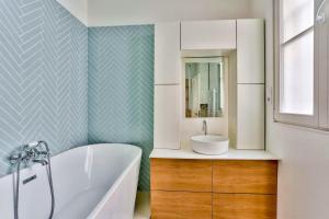 a bathroom with a tub and a sink at Superbe Appartement Bon marché Saint Germain Free Netflix in Paris +19 photos