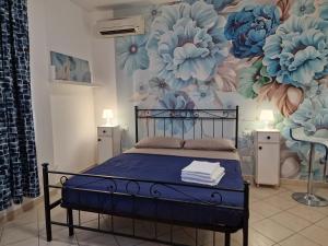 een slaapkamer met een bed met een muurschildering van bloemen bij Casa Mon Amour Livorno in Livorno