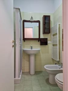 ein Badezimmer mit einem Waschbecken, einem WC und einem Spiegel in der Unterkunft Casa Mon Amour Livorno in Livorno