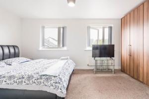 a bedroom with a bed and a flat screen tv at En-suit room with free dedicated parking in Manchester
