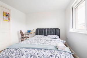 a bed in a white room with a window at En-suit room with free dedicated parking in Manchester