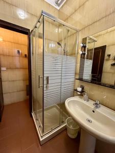 a bathroom with a glass shower and a sink at Dimora '800 in Ferrara