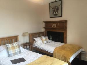 a room with two beds and a fireplace in it at DAVAAR B&B in Dufftown