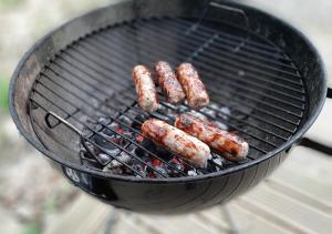 a bunch of sausages cooking on a grill at Cosy Shepherd's Hut with Hot Tub in Church Stretton