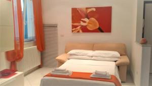 Habitación pequeña con cama y pintura en Appartamento Vacanze Riviera delle Palme, en San Benedetto del Tronto