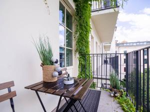 a balcony with a wooden table and plants at Apartament Sukiennicza in Krakow