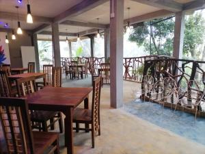 a restaurant with wooden tables and chairs and windows at Kithaya Ella in Ella