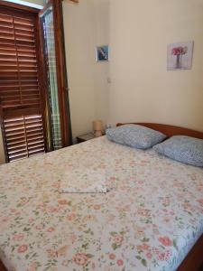 a bedroom with a bed with a floral bedspread at Jasmine in Brodarica