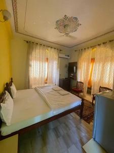 a bedroom with a bed in a room with curtains at Pushkar Heritage in Pushkar