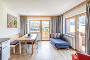 a living room with a table and a blue chair at Rössle Appartement in Bezau