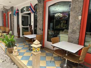 Nid Huahin Hotel في هوا هين: طاولتين وكراسي يجلسون خارج المطعم