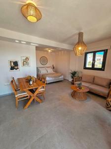 a living room with a table and a couch and a bed at Byblos Cycladic House in Vívlos