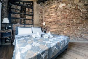 a bedroom with a bed and a brick wall at 31 steps to Heaven - Heart of Lucca in Lucca