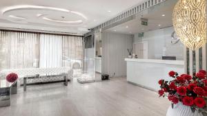 duży salon z czerwonymi kwiatami w wazie w obiekcie Hotel 9 w Zagrzebiu