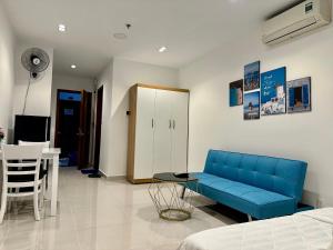 Teddy Apartment at Sky Center Luxury في مدينة هوشي منه: غرفة معيشة مع أريكة زرقاء وطاولة