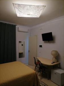 a bedroom with a bed and a desk and a television at B&B Dolce Casa in Vasto