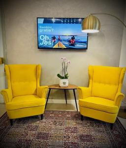 リド・ディ・イエゾロにあるHotel Cristinaの黄色い椅子2脚とテーブル1台