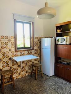 eine Küche mit einem weißen Kühlschrank und einem Fenster in der Unterkunft Grandma's Carolina Villa in Sul