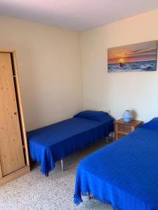 twee bedden in een kamer met blauwe lakens bij Costa Brava Home in Terra Brava