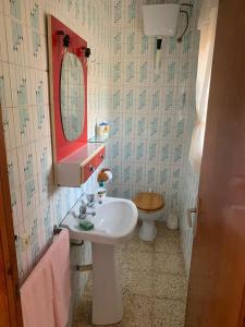 een badkamer met een wastafel, een toilet en een spiegel bij Costa Brava Home in Terra Brava