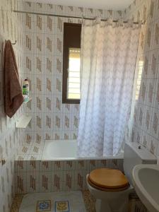 een badkamer met een bad, een toilet en een raam bij Costa Brava Home in Terra Brava
