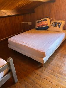 a bed in a room with a wooden floor at Petite maison en bordure de N7 in Piolenc
