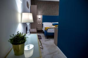 OPERAPRIMASUITE في مسينة: غرفة نوم مع سرير وطاولة مع نبات الفخار