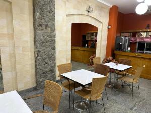 a restaurant with two tables and chairs and a counter at Nid Huahin Hotel in Hua Hin