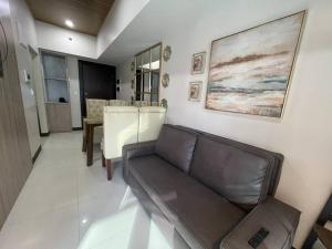 a living room with a couch and a table at Stylish 1BR Uptown Parksuites BGC, 200mbps/SmartTv in Manila