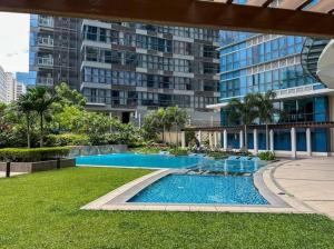 a swimming pool in front of a large building at Stylish 1BR Uptown Parksuites BGC, 200mbps/SmartTv in Manila