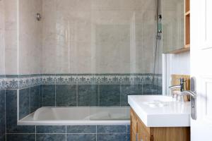 a bathroom with a tub and a sink at Hotel Le Dauphin in Honfleur