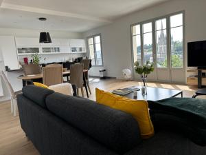 a living room with a couch and a table at Le duplex Saint-Corentin - Hyper Centre - Parking Privé in Quimper