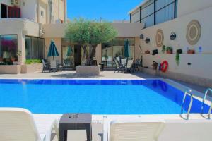 ein großer Pool mit Stühlen und einem Tisch neben einem Gebäude in der Unterkunft Salome Hotel in Madaba