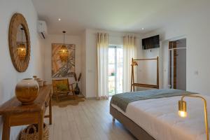 um quarto com uma cama e uma mesa e uma mesa sidx sidx sidx em Coral Boutique Suites em Albufeira