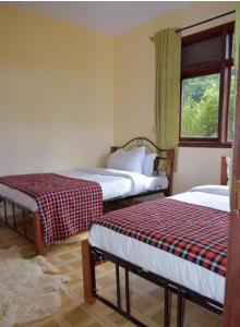 a room with two beds and a window in it at Sunshine maasai mara safari camp in Sekenani