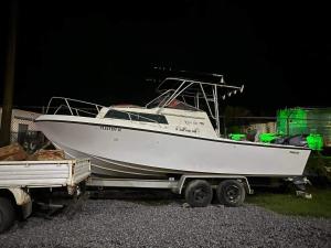 un barco blanco en un remolque junto a un camión en CHINA STAR HOTEL, en Kolonia