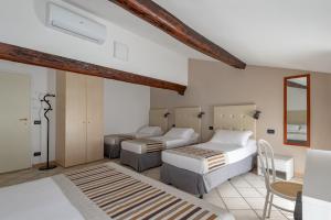 a bedroom with two beds and a mirror at Hotel Mantegna Stazione, MantegnaHotels in Mantova +58 photos