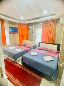 duas camas num quarto com cortinas vermelhas em White Suites Hotel İstanbul em Istambul