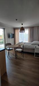 1 dormitorio con cama, mesa, mesa y sillas en Apartamenty Belona, en Stegna