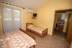 1 dormitorio con 2 camas y puerta al baño en Guesthouse Villa Lena en Premantura