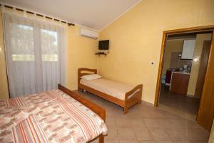 a bedroom with two beds and a door to a bathroom at Guesthouse Villa Lena in Premantura